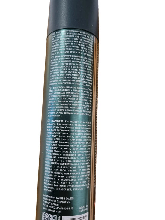 A close-up of the back of a dark green spray can with dense white text, photographed on a wooden tabletop.