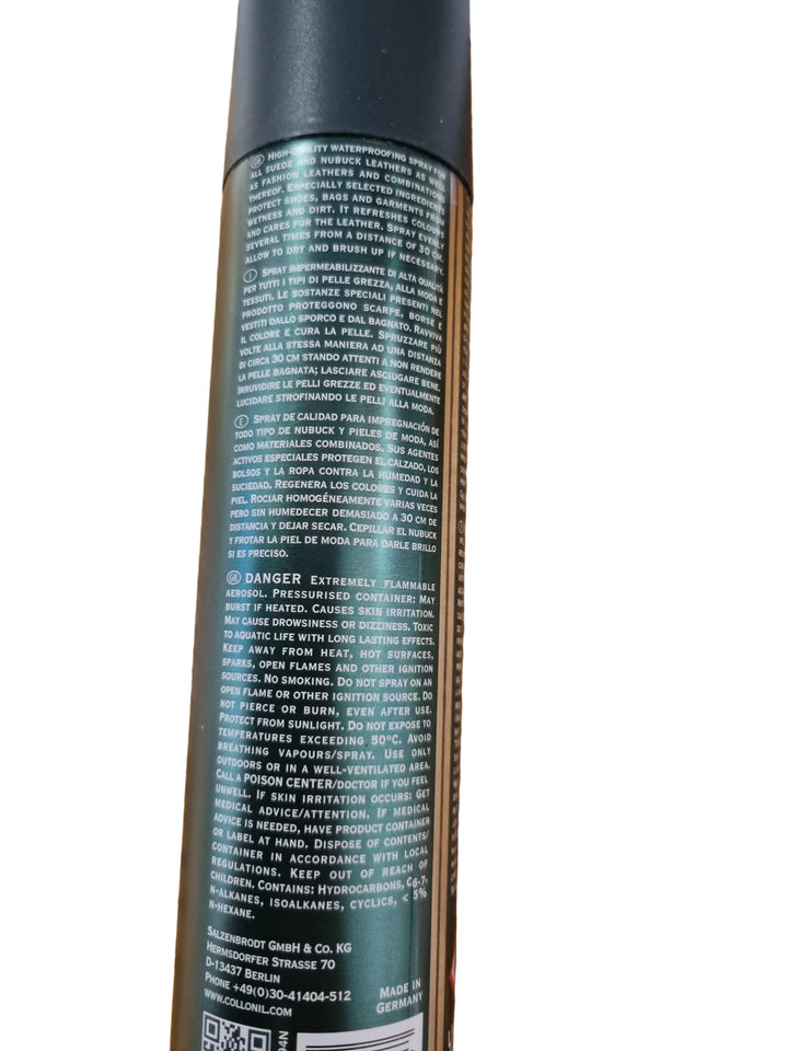 A close-up of the back of a dark green spray can with dense white text, photographed on a wooden tabletop.